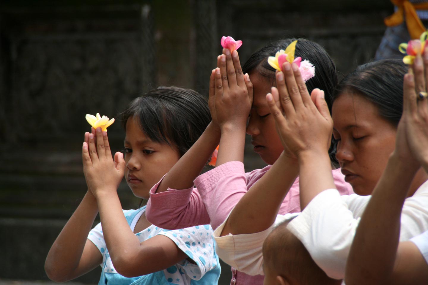משפחה בתפילה לאלים, במקדש באי באלי, אינדונזיה